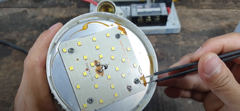 Dùng nhíp đã được cách điện hoàn toàn để kiểm tra từng con chip trên mạch LED của đèn